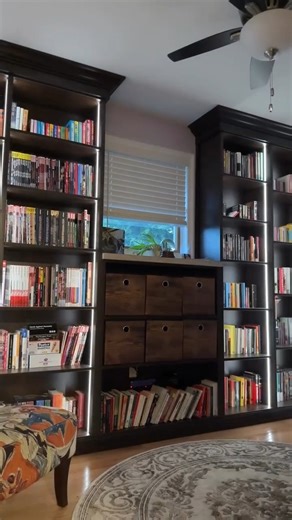 Custom shelving seamlessly blends style and functionality into beautiful storage. These exquisite bookcases turn the entire wall into a captivating piece of art. #ClosetsbyDesign #HomeOrganizers #BookshelfBliss #CustomLibrary #CustomStorage #Declutter #HomeLibrary | Closets By Design