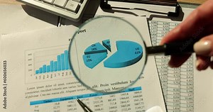 Magnifying glass focusing on diagram and analytical report. Sales statistics and target audience targeting
