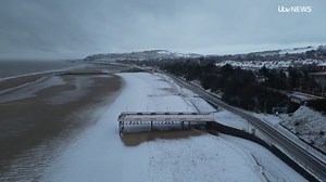 These were the wintery scenes people woke up to in Colwyn Bay this morning, as snow blanketed the beach and gritters lined the A55. | ITV Wales