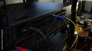 Network technician connects and checks cables on a network switch