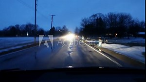 Windshield view noir style shot of car driving at night in low moving fog.
