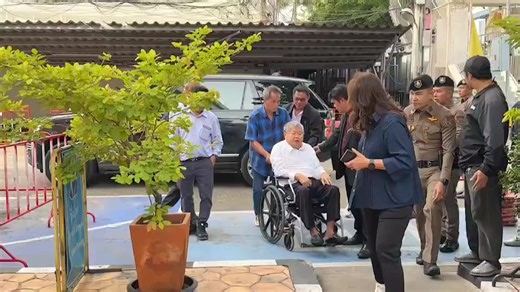 Premchai Karnasuta, Chairman of Italian-Thai Development Company, one of 17 individuals with arrest warrants in the State Audit Office building collapse case, arrived in a wheelchair to meet with investigators at Bang Sue Police Station | Khaosod English