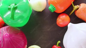 Hand taking vegetables and plastic vegetable shape storage containers from table