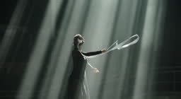 Silhouette of Ballerina performing with white ribbon in dramatic...