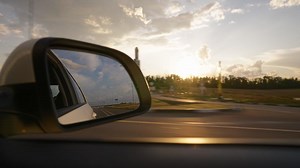 View from the side window of a car driving fast along the highway during a beautiful sunset. Travel trip and adventure concept.
