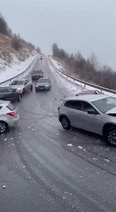Black Ice Turns Hill Into a Slip-and-Slide, Triggering Multi-Car Crash November 30, 2025 – Asheville, North Carolina What began as a light dusting of morning snow turned into a highway nightmare when a hidden sheet of black ice sent car after car spinning helplessly down a steep mountain road. The video—captured by a driver who had wisely stopped at the bottom of the hill—shows exactly how fast things unraveled. The first vehicle, a gray sedan, attempts to brake but instantly begins sliding side