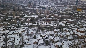 Aerial cinematic drone winter Olympic downtown snowy streets roads Sarajevo City center avaz twist Bosnia and Herzegovina cars and highway frozen war ruins landscape mid day slow forward movement
