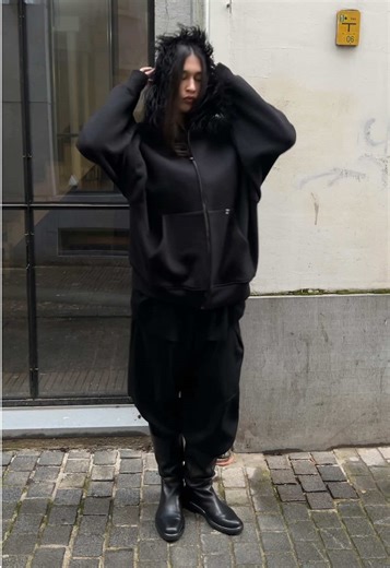 Alyx Feathered Zip Hoodie - AW22 Hooded raglan cut sweater from the Alyx Fall Winter 2022 collection designed by Matthew Williams. Tonal ostrich fur embellishment going around the hood. Silver zip closure with a ribbed waistband and sleeve cuffs. Signature metal clip hardware at the cangaroo pocket. Made from a thick. trimmed cotton in black. Oversized cut. Retailed for around 700€.