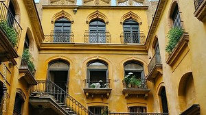 A yellow building with intricate details and balconies in a Spanish city