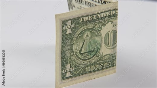 Close up of Eye of Providence symbol of pyramid on U.S. United States of America printed cash money one 1 dollar bill in tight slow motion of triangle meaning as All-Seeing Eye Great Seal one-dollar