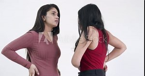 Two pretty ladies touch and caress each other with tender romantic embrace, dance and discuss sweet nothings face to face, mid-shot on white studio background isolated slow-motion handheld 60fps