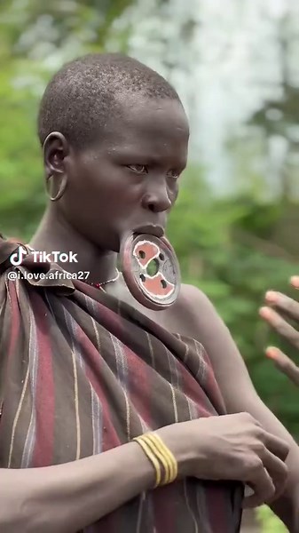 Mursi Woman Inserting Lip Plate: A Cultural Insight