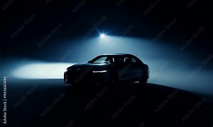 A dramatic silhouette of a car with headlights on, set against a dark background, highlighting the vehicle's shape in low light