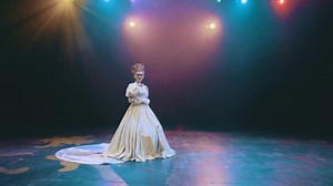 A theater actress with flowers in her hands in a brides dress on stage. opera. performance. the tsars bride.