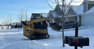 Steering everyone clear: Landscapers use heavy machinery to clear ice and snow off driveways