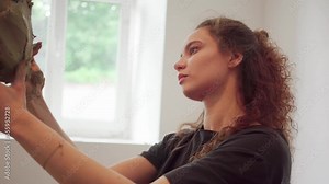 Female artisan making clay sculpture shaping the form by hands in her workshop