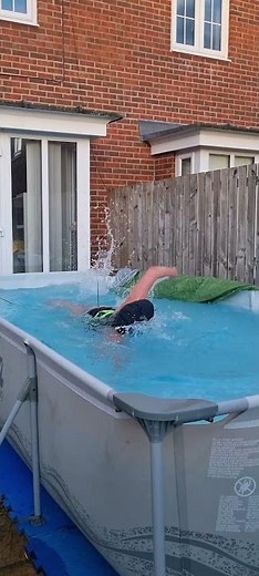 Swimmer is training in a pop up pool using a swim float belt and bungees!