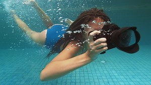Photographer diving in a pool with a waterproof camera - Free Stock Video