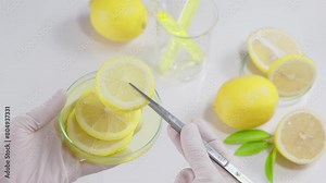 Experiment for obtaining an extract from fresh yellow lemon, research on the properties of lemon for manufacturing cosmetic or beauty products. Top view video, white background