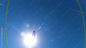 paragliders fly in a clear cloudless blue sky one after another from left to right. bottom view against the sun. Extreme and active types of recreation. view from gopro. High quality FullHD footage