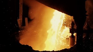 Heavy Stream of Hot Liquid Metal. Bright Sparks Fire and Smoke in Induction Furnace. Metal Casting Foundry. Slow Motion. Metallurgy Industry. Heating and Melting Process of Material.