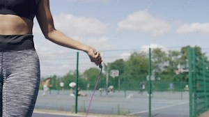 Half body shot of a female skipping with a jump rope with space for text, in slow motion