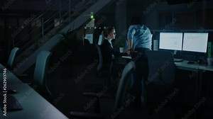 Confident Businessman Uses Desktop Computer, Her Male Manager Explains Specific Tasks, Account Handling and Strategy. Professional People Working Late at Night in Corporate Office