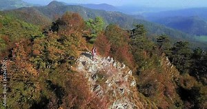 AERIAL 4K: Outdoor activity. Happy adventurous couple in love admiring the view from the mountain top hugging each other. Camera following subject.