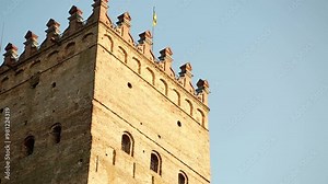 Middle Age Castle. Brick Сastle. The Castle that was founded in the 14th Century. Lubart's Castle. Flag of Ukraine. Medieval stronghold. The flag of Ukraine flying on the tower of the medieval castle.