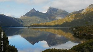 morning shot of cradle mountain reflected on a calm dove lake in tasmania, australia