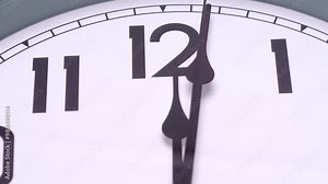 Close-up White clock tells the time after midnight, start of a new day.