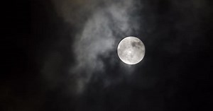 Full Moon Shines Through Clouds at Night