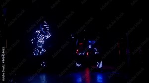 Light dance show performance on stage in club. Mirror and glowing clothes on futuristic dancers at event. Stable low light shot on gimbal with movement