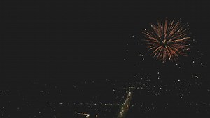Beautiful fireworks display being shown for a city below - Free Stock Video