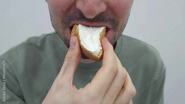 Man eating bread with cream cheese. Close-up of hands and food. Snack and meal concept.