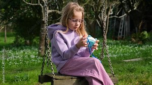 Video of child playing on electronic pop it fidget and riding a swing. Stress relieve toy pop it. Child playing Electronic Pop It. Simple board game.