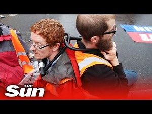 Furious driver snatches Insulate Britain signs & cops free protesters chained together