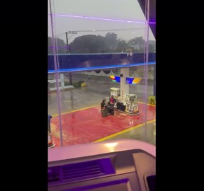 Motorcycle rider uses metal stand as improvised umbrella
