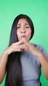 Long-haired woman makes mocking gestures with her mouth looking at...