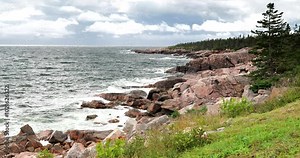The Cabot Trail in Nova Scotia, featuring breathtaking views of rolling hills and a winding road through lush landscapes along the coast