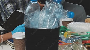 Garbage separation concept. Female hands separate paper and plastic into separate containers in the kitchen at home. Waste segregation, waste sorting, waste recycle.