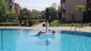 Woman on inflatable pool float in pool in hotel. Summer holidays, enjoying summer vacations.