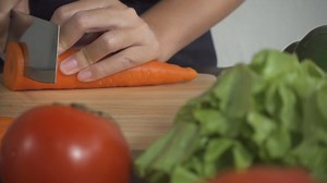 Download Close up of a woman chopping a carrot  for free