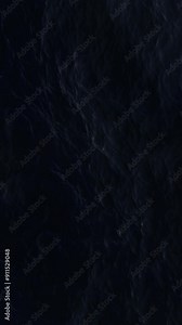 Vertical aerial view of the dark ocean. Ripples and waves on deep water surface. Turbulent sea reflects the bright moonlight. Soft and relaxing movement. Night top view. Liquid background.