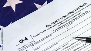 Employee's Withholding Certificate W4 footage with USA flag, 4k.W-4 form on American flag.