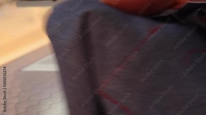 Male Tailor cutting thread with scissors by an industrial sewing machine