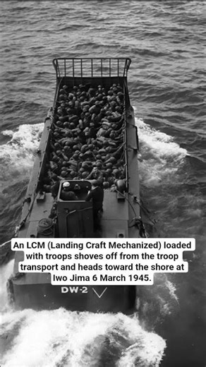 An LCM (Landing Craft Mechanized) loaded with troops shoves off from the troop transport