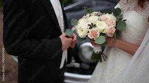 bride with a bouquet and groom near a retro car