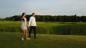 Couple Embracing And Kissing Outdoors, Shooting From Drone Circling Above, Romanic Man And Woman Walking In Park Aerial View