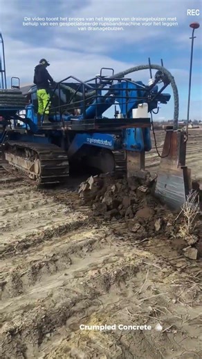 Het aanleggen van een flexibele geperforeerde drainagebuis met behulp van een drainagemachine